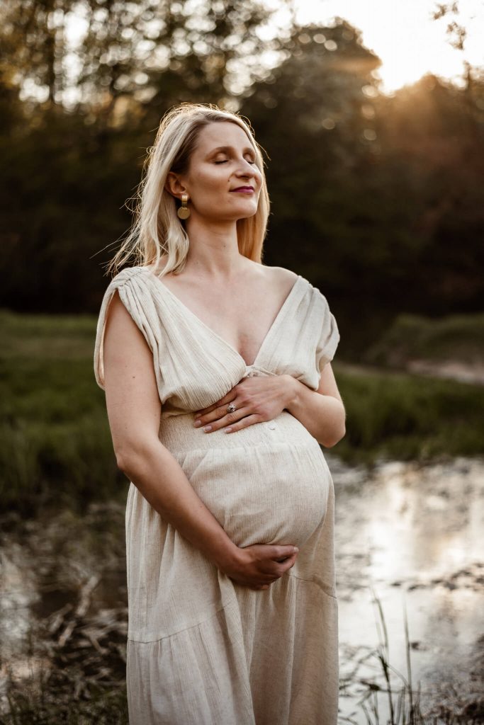 Babybauchfotos in Nürnberg Schwangere steht am Wasser