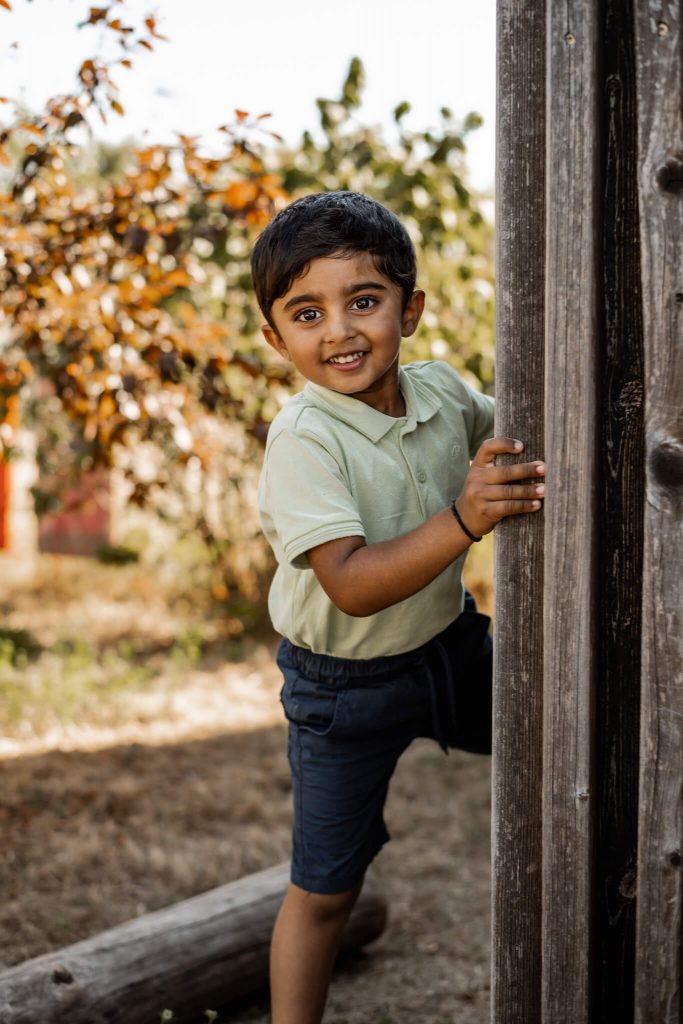 Kindergartenfotografie in Nürnberg Kindergartenkind versteckt sich