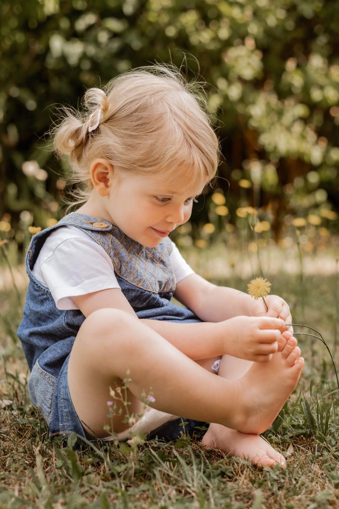 Kindergartenfotografie in Nürnberg Kindergartenkind spiel mit Blume