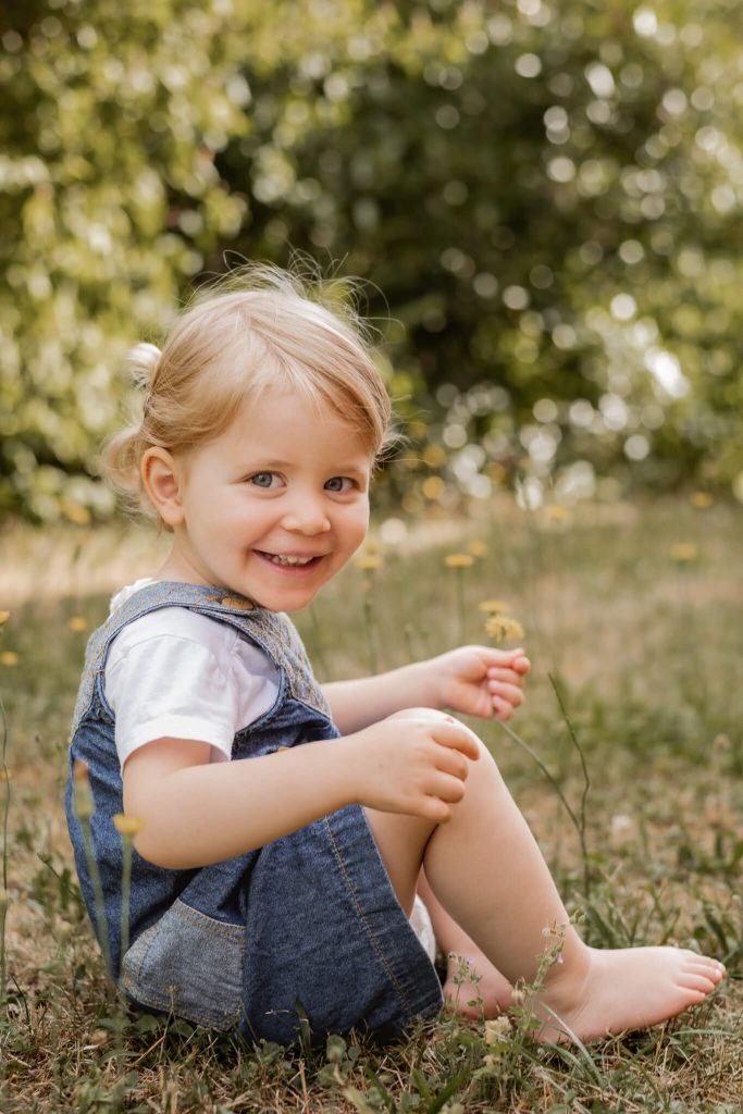 Kindergartenfotografie in Nürnberg Kind sitzt im Gras